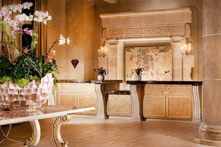 Elegant hotel lobby with marble reception desks, orchid flowers, and classical architecture