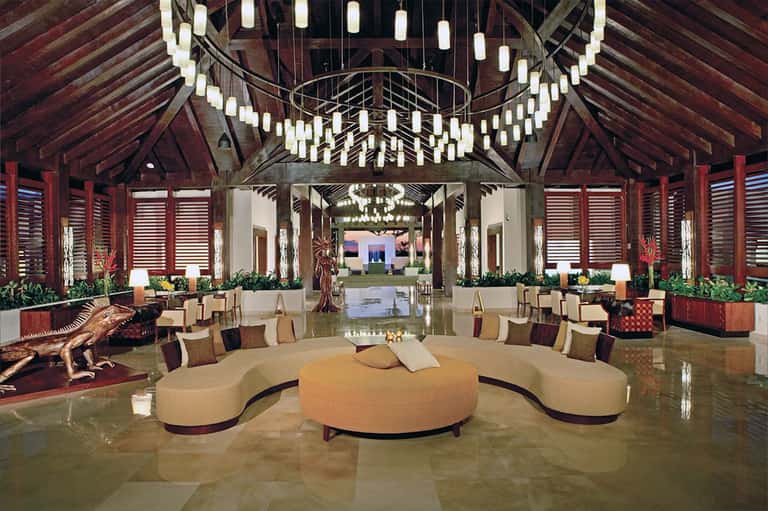 Luxurious resort lobby with high wooden ceiling, elegant seating, and chandelier lighting