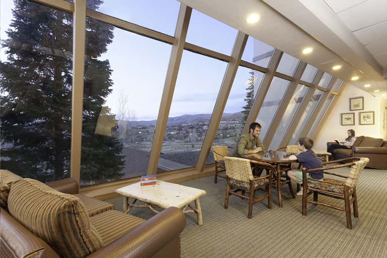 Modern lounge with floor-to-ceiling windows offering mountain valley views and comfortable seating