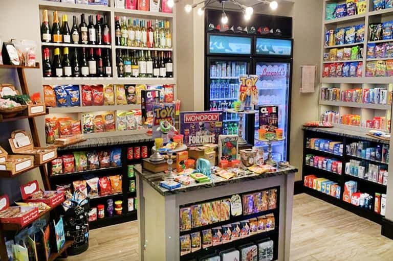 Resort gift shop interior with wine bottles, board games, snacks, and refrigerated beverage display