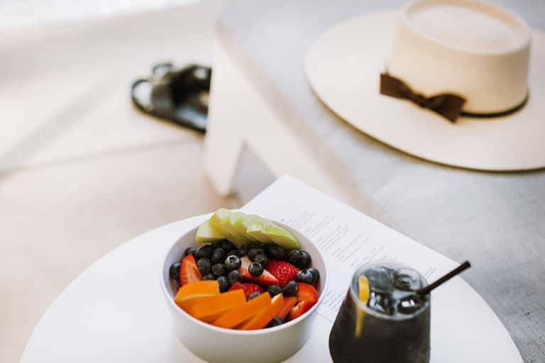Elegant plated dessert bowl with fresh fruit and berries alongside refined tableware