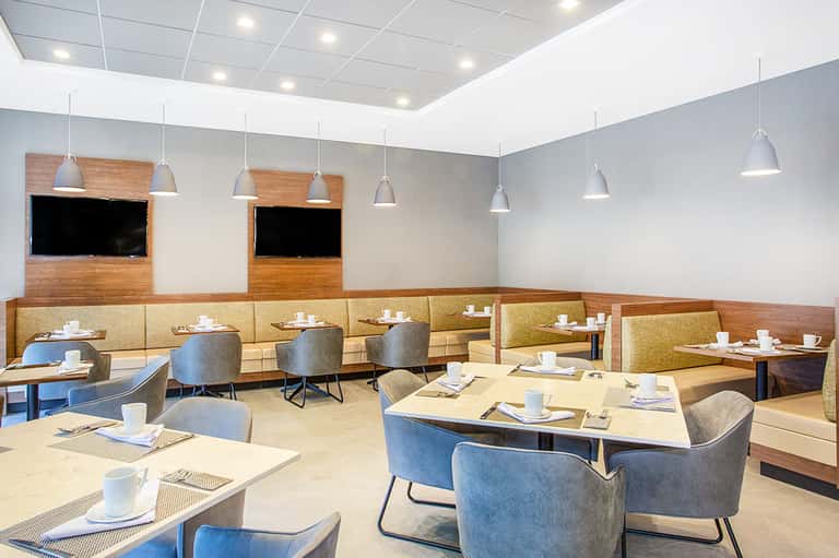 Modern restaurant interior with booth seating, pendant lights, and wood accents