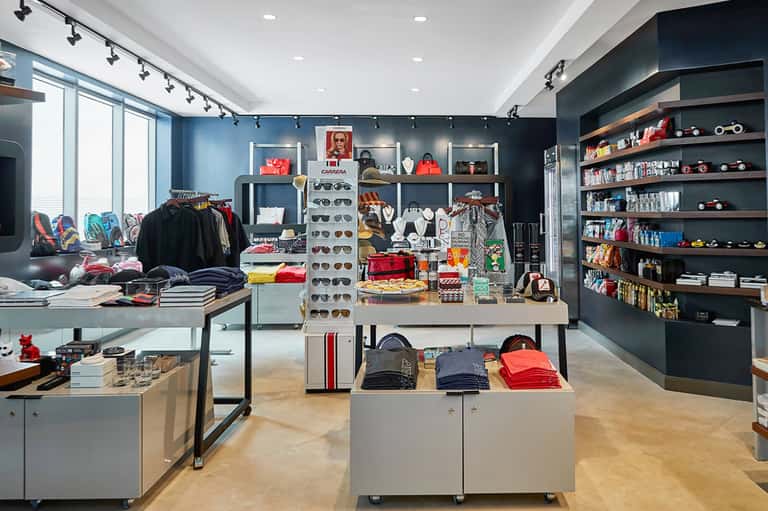 Retail boutique interior with clothing displays, sunglasses, and shelving