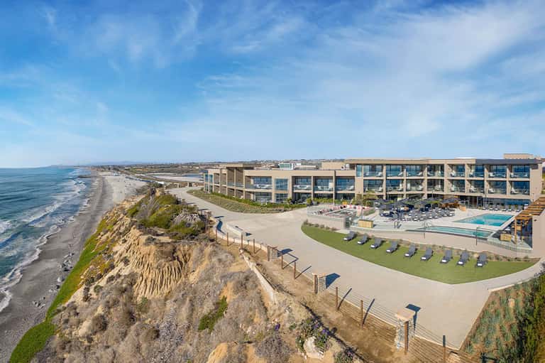 Modern beachfront resort building perched on coastal cliffs with ocean and beach views