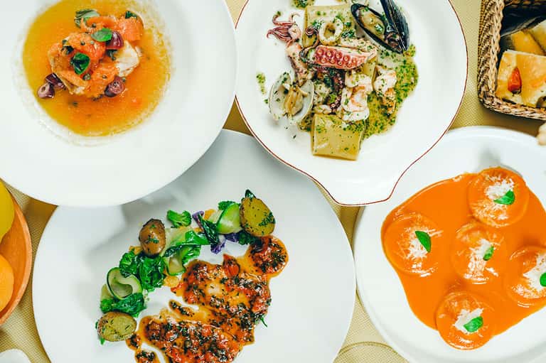 Fine dining plates featuring seafood, pasta, and colorful sauces