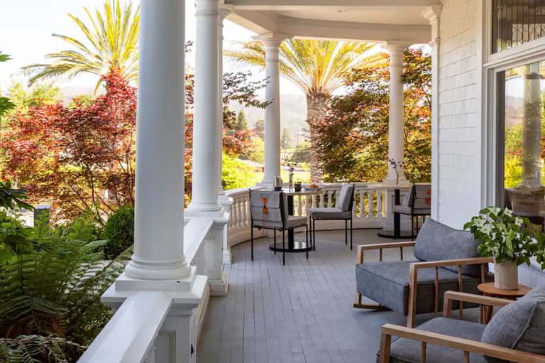 Covered porch with columns, lounge seating, and mountain landscape views