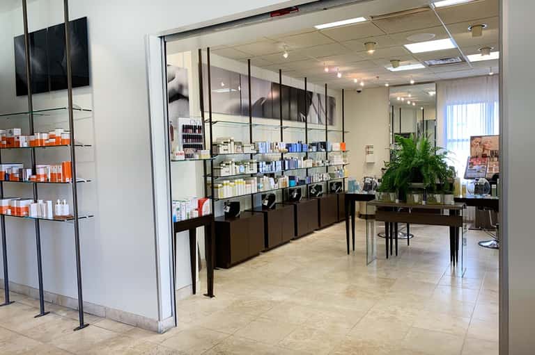 Modern spa retail boutique with glass storefront, product displays, and minimalist design
