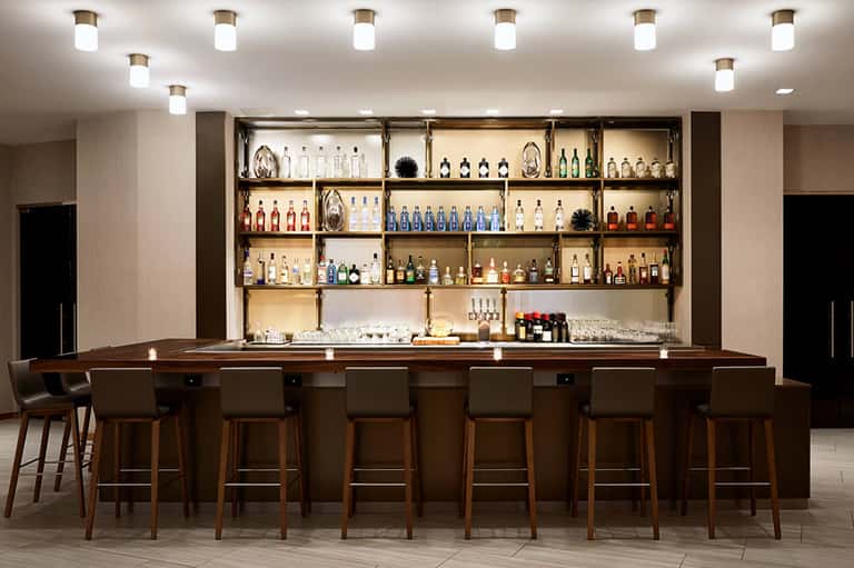 Full-service resort bar with extensive liquor collection on illuminated shelves