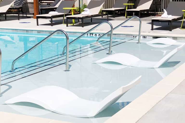 Hot tub and swimming pool area with loungers and yellow accent furniture
