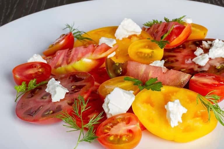 Colorful heirloom tomato salad with fresh mozzarella and herbs