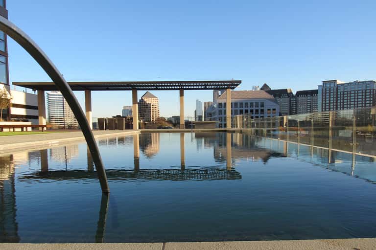 Outdoor infinity pool reflecting urban skyline with modern architectural structures