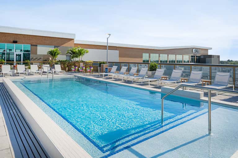 Rooftop pool with lounge chairs overlooking coastal landscape
