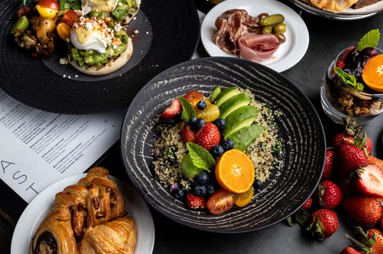 Overhead view of elegant brunch spread with quinoa bowls, pastries, and charcuterie