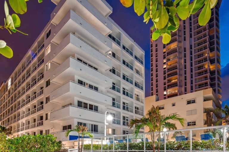 Modern beachfront resort buildings at dusk with tropical landscaping