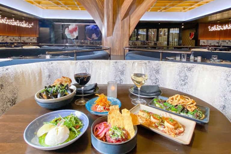 Modern restaurant interior with contemporary plated dishes and wine glasses at counter seating