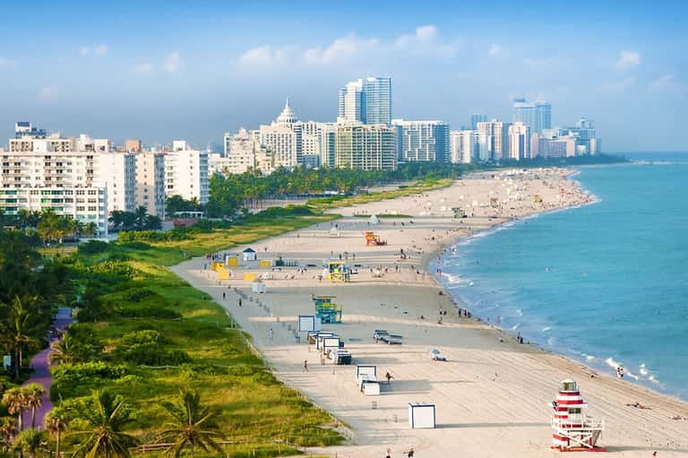 Aerial view of Miami Beach coastline with sandy shores, buildings, and turquoise ocean