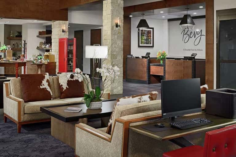 Hotel reception area with wood tones, stone columns, and Berry by Hilton sign
