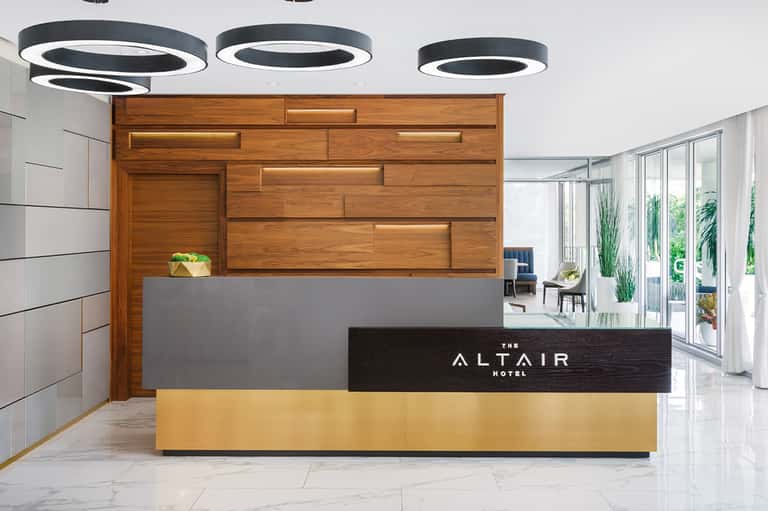 Hotel reception desk with modern design, wood backdrop, and minimalist decor