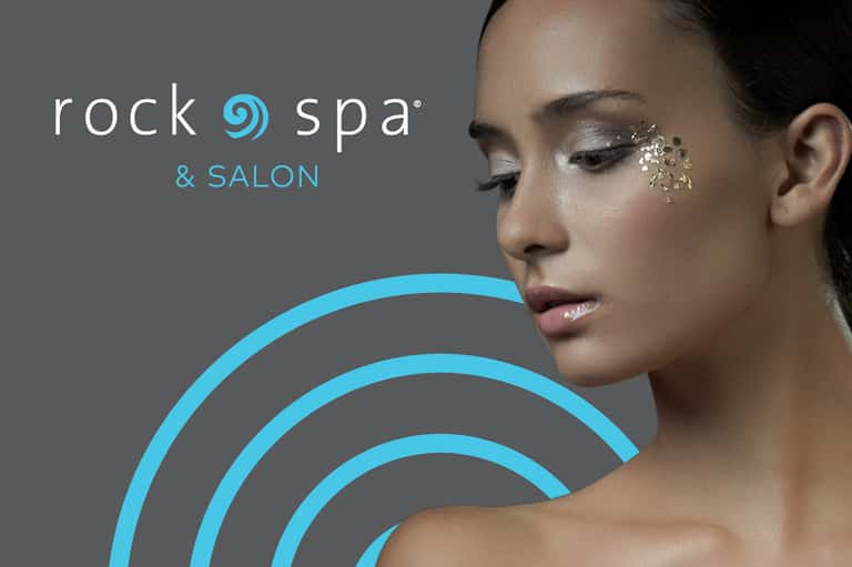Rock Spa & Salon logo with woman's face and sparkling eye makeup on gray background