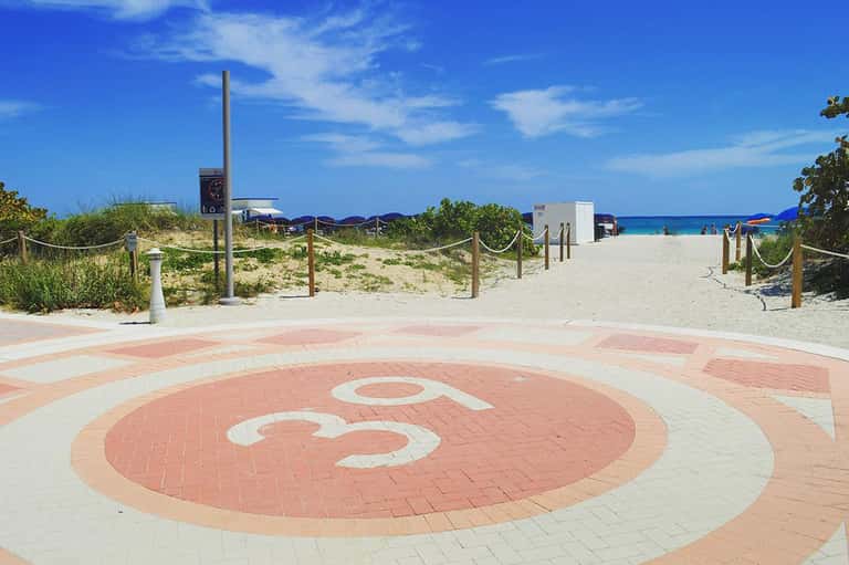 Beachfront promenade with Beeman Hotel logo leading to sandy beach