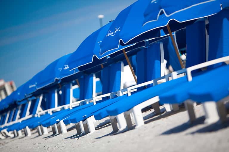 Close-up of bright blue beach cabanas with white trim and wooden details