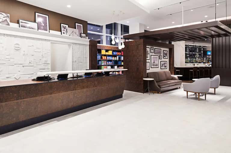 Contemporary hotel lobby with brown cork accent wall, reception desk, and modern seating area