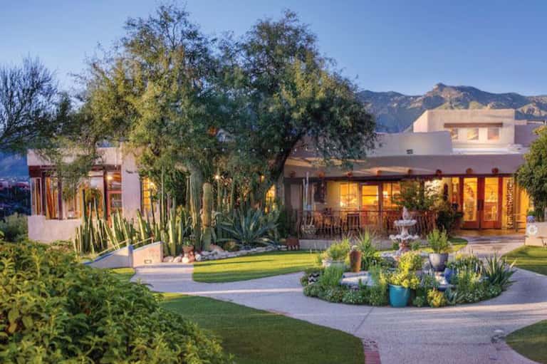 Modern residential home with terracotta exterior, desert landscaping, and mountain backdrop