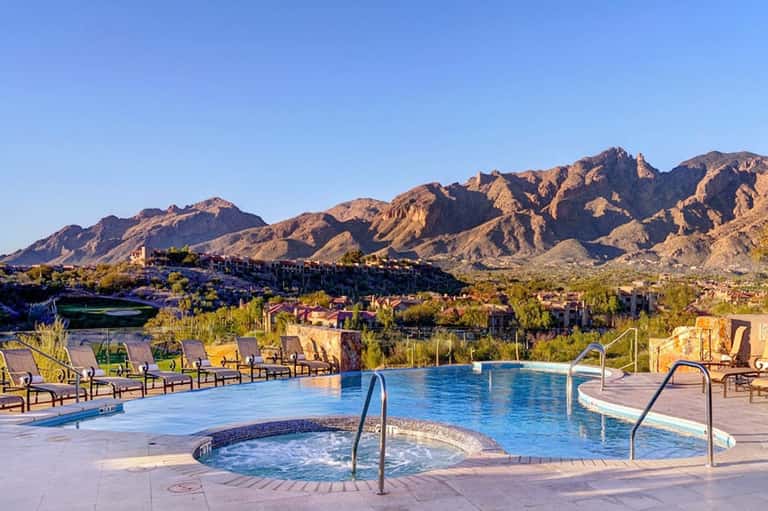 Resort pool with spa and mountain views, lounge chairs, desert landscape
