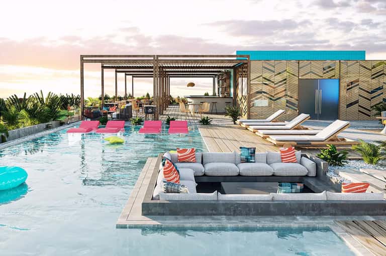 Modern resort pool with sunken lounge area, pink floats, and contemporary architecture