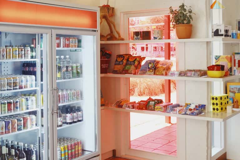 Bright retail shop interior with refrigerated beverages and colorful product shelving