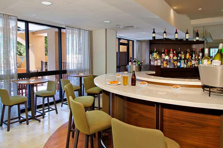 Contemporary resort bar and lounge with seating, full bar, and patio access