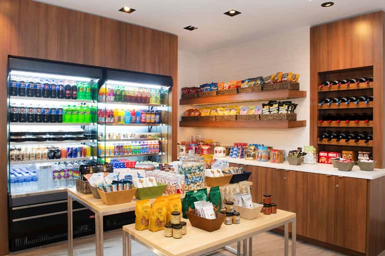 Hotel convenience store with refrigerated beverages, snacks, wine bottles, and merchandise