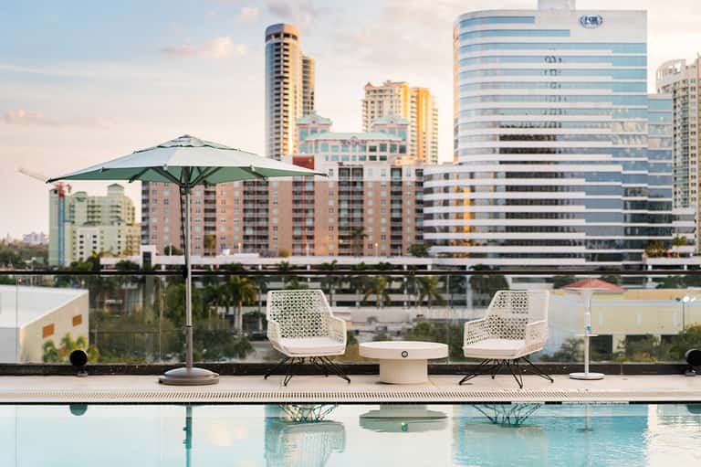 Modern rooftop lounge area with infinity pool and city skyline backdrop