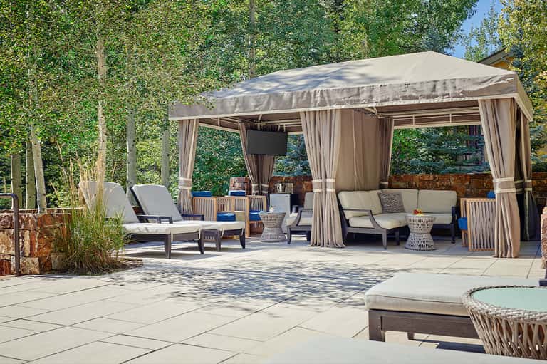 Outdoor patio with large covered gazebo, lounge furniture, and tree-lined setting