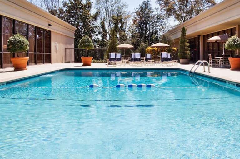 Olympic-style indoor swimming pool with lane dividers, lounge chairs, and modern facility design
