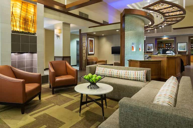 Modern hotel lobby with brown leather seating, geometric artwork, and contemporary design elements