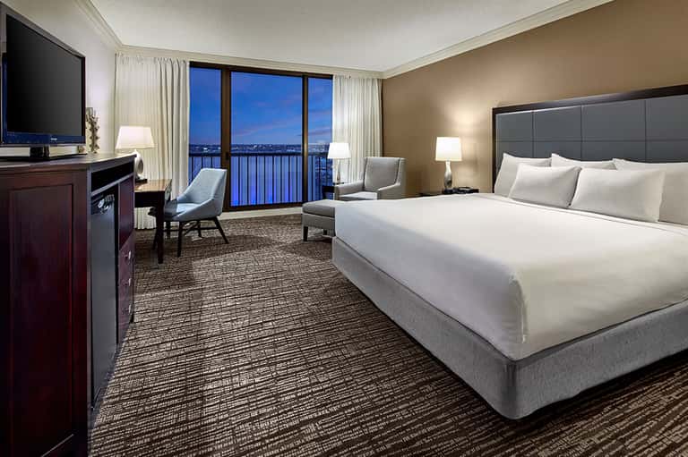 Luxury hotel room with king bed, balcony view, and modern furnishings