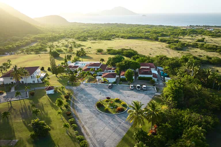 Aerial view of sprawling resort with landscaped grounds and ocean vista