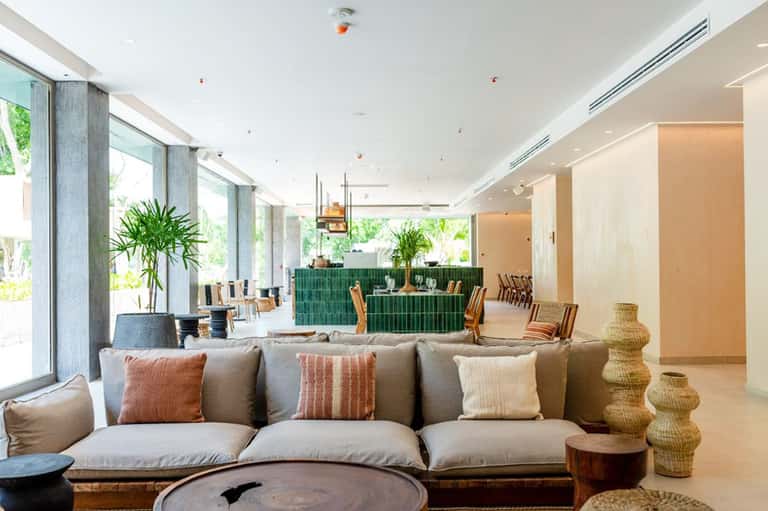 Modern hotel lobby lounge with neutral tones, comfortable seating, and large windows
