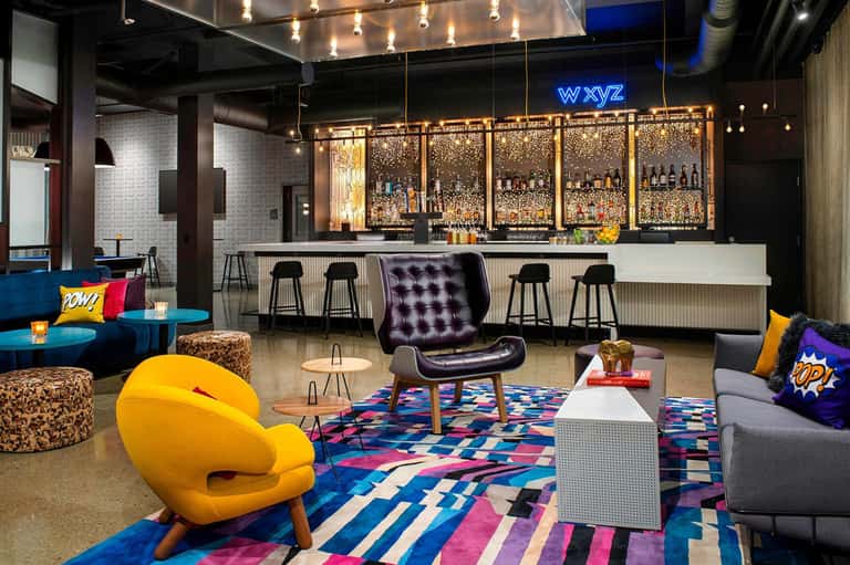 Modern hotel lounge with colorful seating, bar, and contemporary design elements
