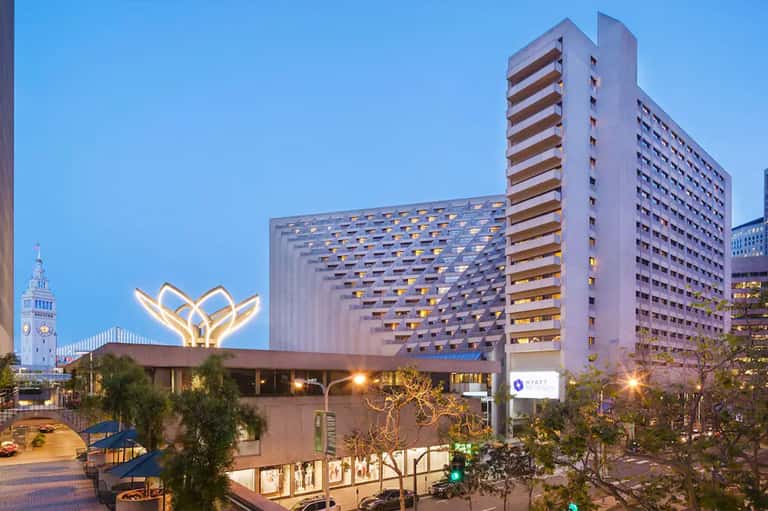 Hyatt hotel exterior at twilight featuring distinctive illuminated lotus-shaped roof sculpture and tower