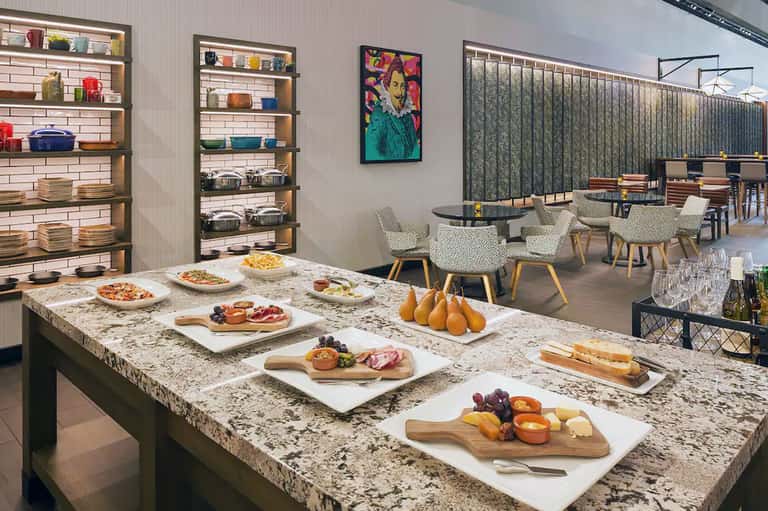 Modern hotel restaurant with granite countertop, open kitchen, food displays, and casual dining area