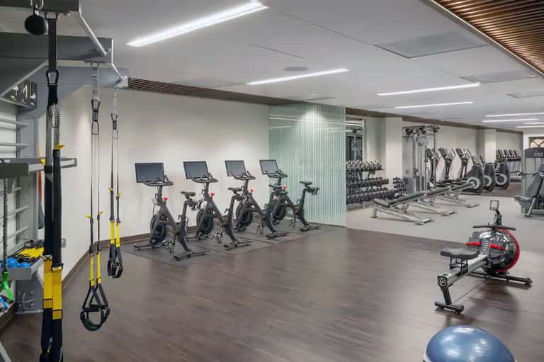 Modern fitness center with stationary bikes, weights, and suspension training equipment