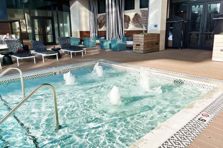 Indoor hot tub with jets and bubbling water surrounded by loungers and modern decor