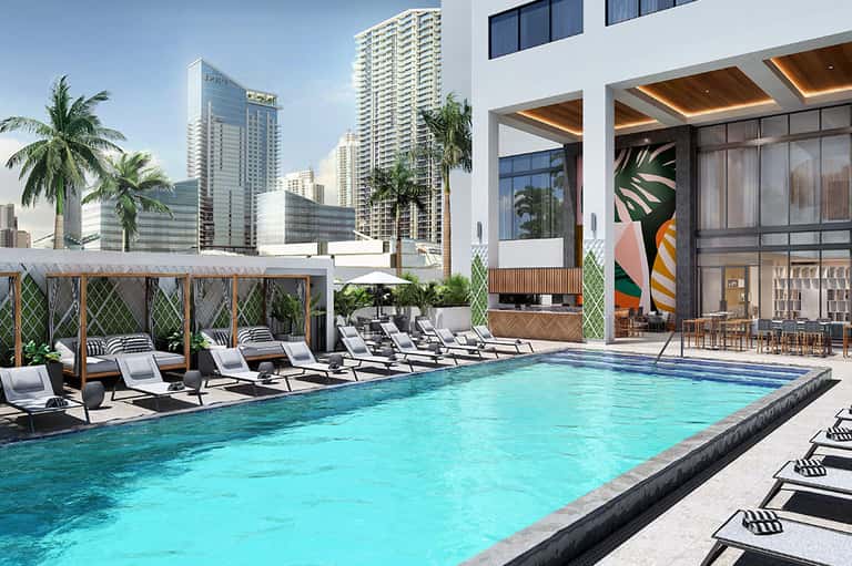 Modern rooftop pool with turquoise water, sun loungers, wooden pergolas, and city skyline views