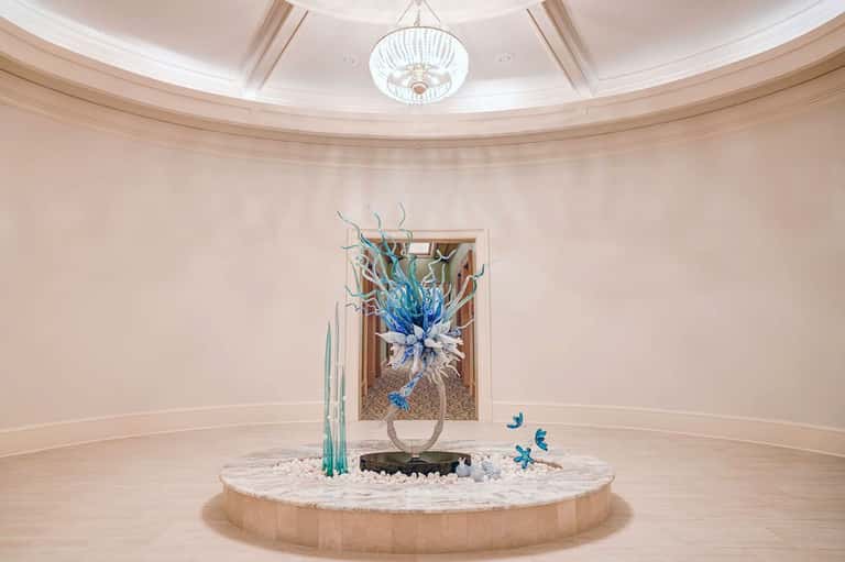 Elegant circular lobby with domed ceiling and blue glass sculptural centerpiece