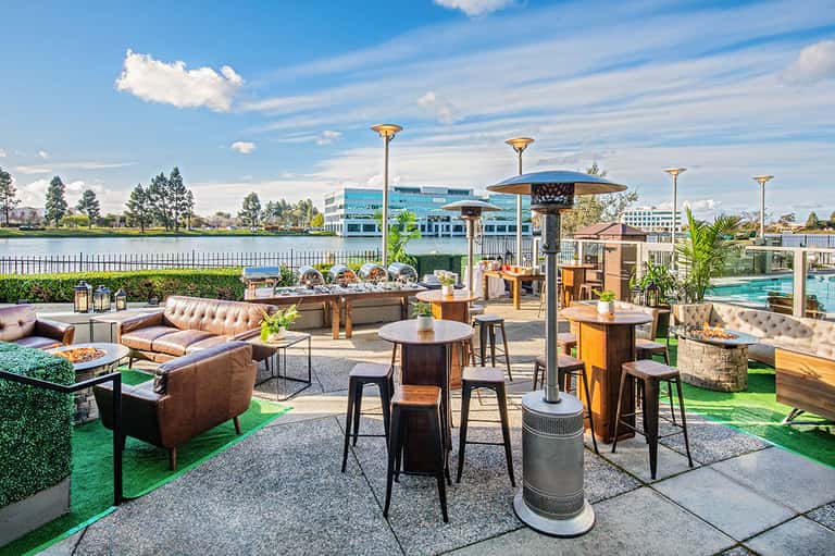 Upscale outdoor terrace with leather seating, firepit, and waterfront views