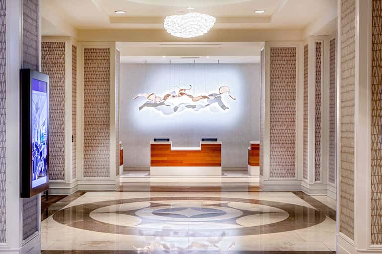 Elegant hotel lobby with marble floors, modern sculpture, and wooden reception desk