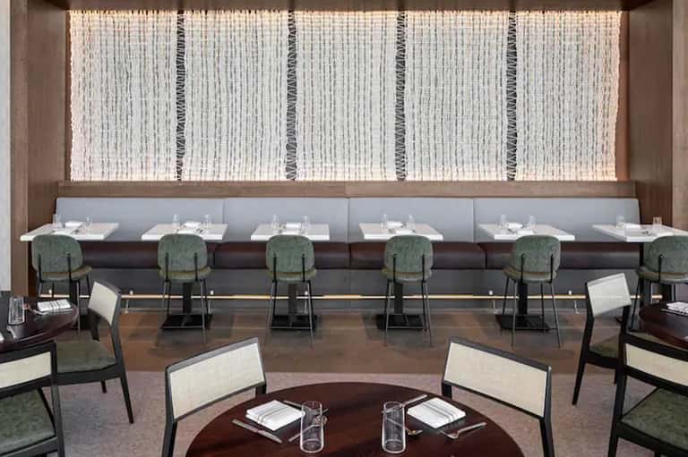Fine dining restaurant with booth seating and modern woven wall panels