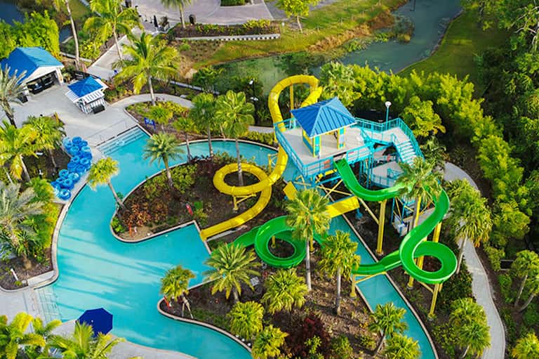 Aerial view of resort with colorful water slides, pools, and tropical landscaping